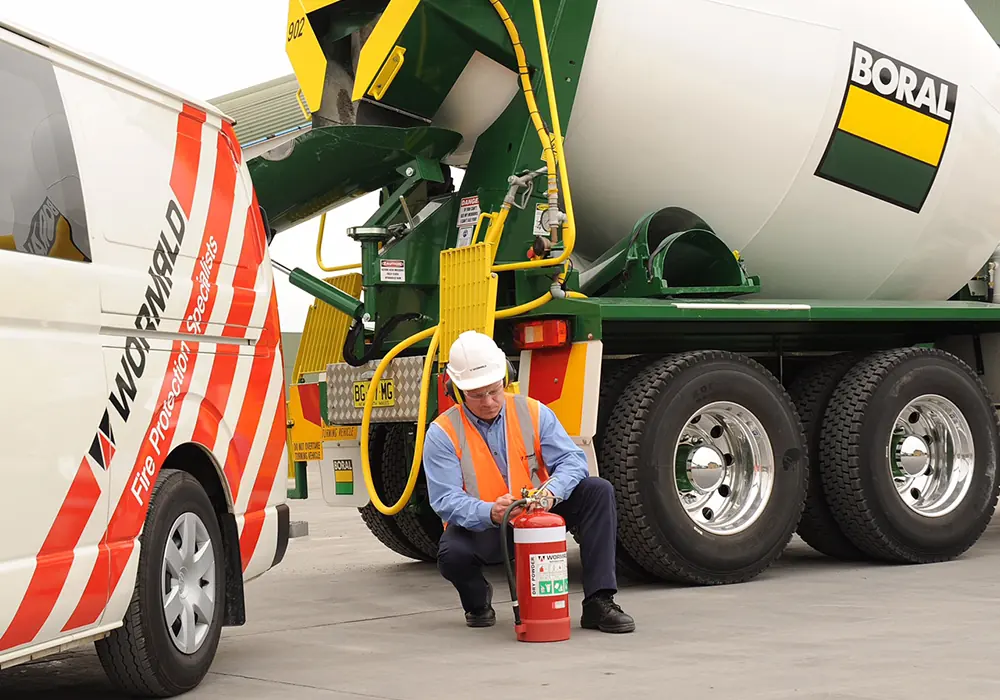 Wormald service technician beside a fire truck